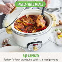 Cream slow cooker with glass lid open, showing a large batch of cooked chicken