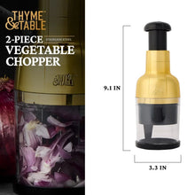 Gold and black 2-piece vegetable chopper with clear container and stainless steel blades