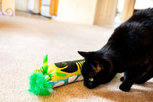 Cat playing with plush fish bone kicker toy with green pom pom