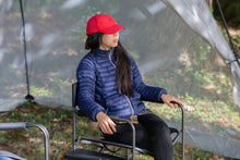 Black folding director's chair with side table outdoors, padded seat and back