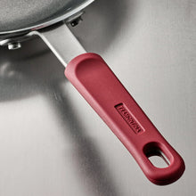 Nonstick fry pan handle close-up with red grip and metal rivets