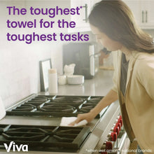 Paper towel in use on a kitchen counter, person wiping with Viva towels