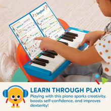 Mini musician's piano with color-coded songbook and hands on the keys