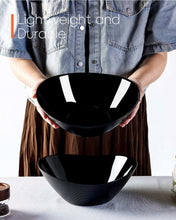 Black ribbed oval salad bowls held in hands, set of 2