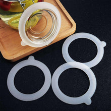 White silicone sealing ring gaskets for mason jar lids, three round loops on tray