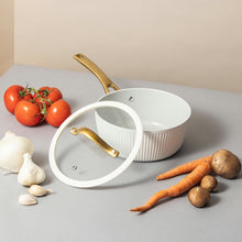 Ribbed non-stick saucepan with gold handle and white lid, lid set beside pan