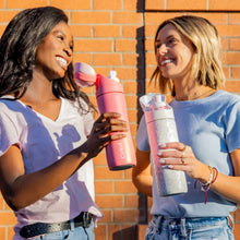 Coral pink insulated flip-top water bottle held upright for sipping