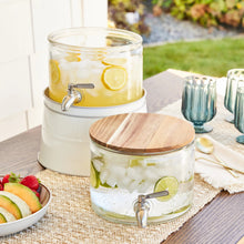 Two-tier glass beverage dispenser with acacia-style wood lid, metal spigot, white base