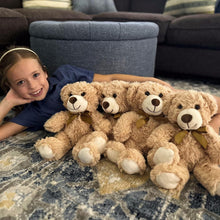 Tan plush teddy bear set with bow ties on a patterned blanket