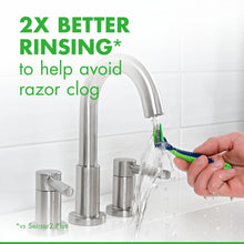 Disposable razor with green handle rinsed under running water over blades.
