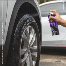 Wet tire finish spray can held near silver car wheel