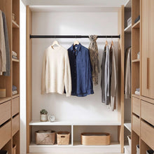 Black closet rod in wardrobe with shirts hanging from hangers
