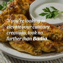 Seasoned chicken pieces with herbs on a plate with a small bowl of sauce