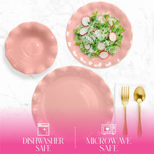 Top view of rose pink scalloped dinner plates and bowl with salad