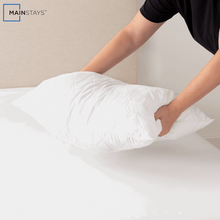 White quilted cluster king bed pillow being adjusted by person