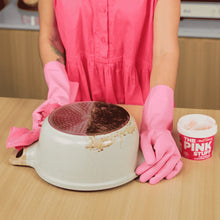 Pink cleaning paste tub on a table near a wiped stovetop