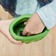 Hands holding green inflatable smash fist glove toy opening