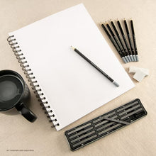 Spiral sketch pad with blank white pages, black spiral, pencils and eraser on the side