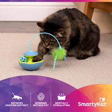 Gray tabby cat playing with blue and lime electronic toy and dangling feather wand.