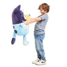 Light blue and purple plush character with yellow muzzle, upright and supported