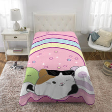 Plush blanket on bed with pink background, rainbow stripes, and three animal faces