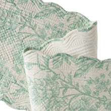 Quilted green-and-white table runner with floral print and grid quilting, scalloped edge