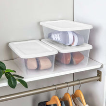 Clear plastic storage bin set with snap-on lids, holding folded items on shelf