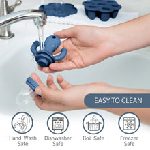 Blue silicone feeder teether pieces rinsed with water in the sink