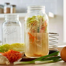 Clear wide-mouth mason jar with metal lid, Ball logo, vegetables inside