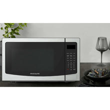 Frigidaire stainless steel countertop microwave oven with black glass door and right-side keypad
