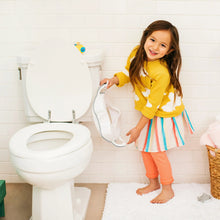 Toddler potty seat attachment with built-in handles on toilet, light-colored