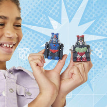 Transformers robot action figures held up by a smiling child, blue and green