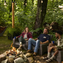 Dark gray patio chairs with slatted backs arranged around a fire pit