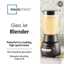 Glass jar blender with clear jar holding pale liquid and black motor base