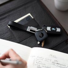 Black Tile tracker on a keyring with keys and wallet on leather