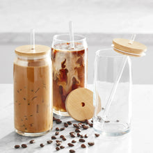 Glass drinkware cups with bamboo lids and clear straws, filled iced drinks