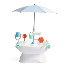 Outdoor water play table with white basin, colorful parts, and light-blue umbrella canopy