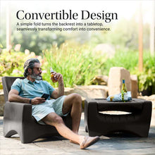 Dark gray patio chair with slatted back and curved armrests on a patio