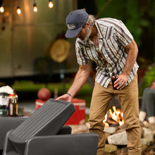 Dark gray patio chair with slatted back, wide armrests, and low rounded seat