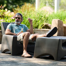 Two dark gray patio chairs with slatted backs and contoured, rounded frames