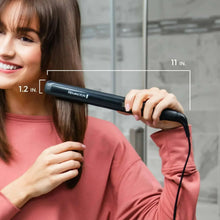 Remington flat iron in use, held near hair with black handle and purple plates