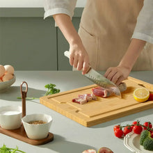 Bamboo cutting board with juice groove and side handles, rectangular serving board.
