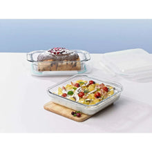 Rectangular glass food containers with clear lids, plated meal