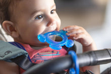 Infant teething set with blue hand-shaped teether, held by baby
