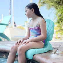 Kids flip seat with scallop shell back, teal molded plastic, child seated on it