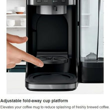 Black coffee maker with adjustable fold-away cup platform and open brew compartment