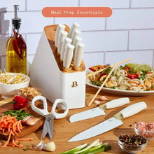 White knife block set with white-handled stainless knives, plus kitchen prep cut on board