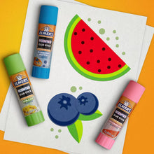 Scented clear glue sticks set with green, blue, and pink sticks on craft paper.