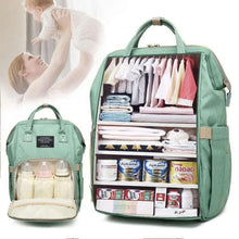 Green diaper backpack set, one open organizer with folded clothes and formula bottles