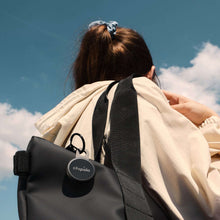 Black Chipolo LOOP Bluetooth tracker attached to a bag, with keyring loop